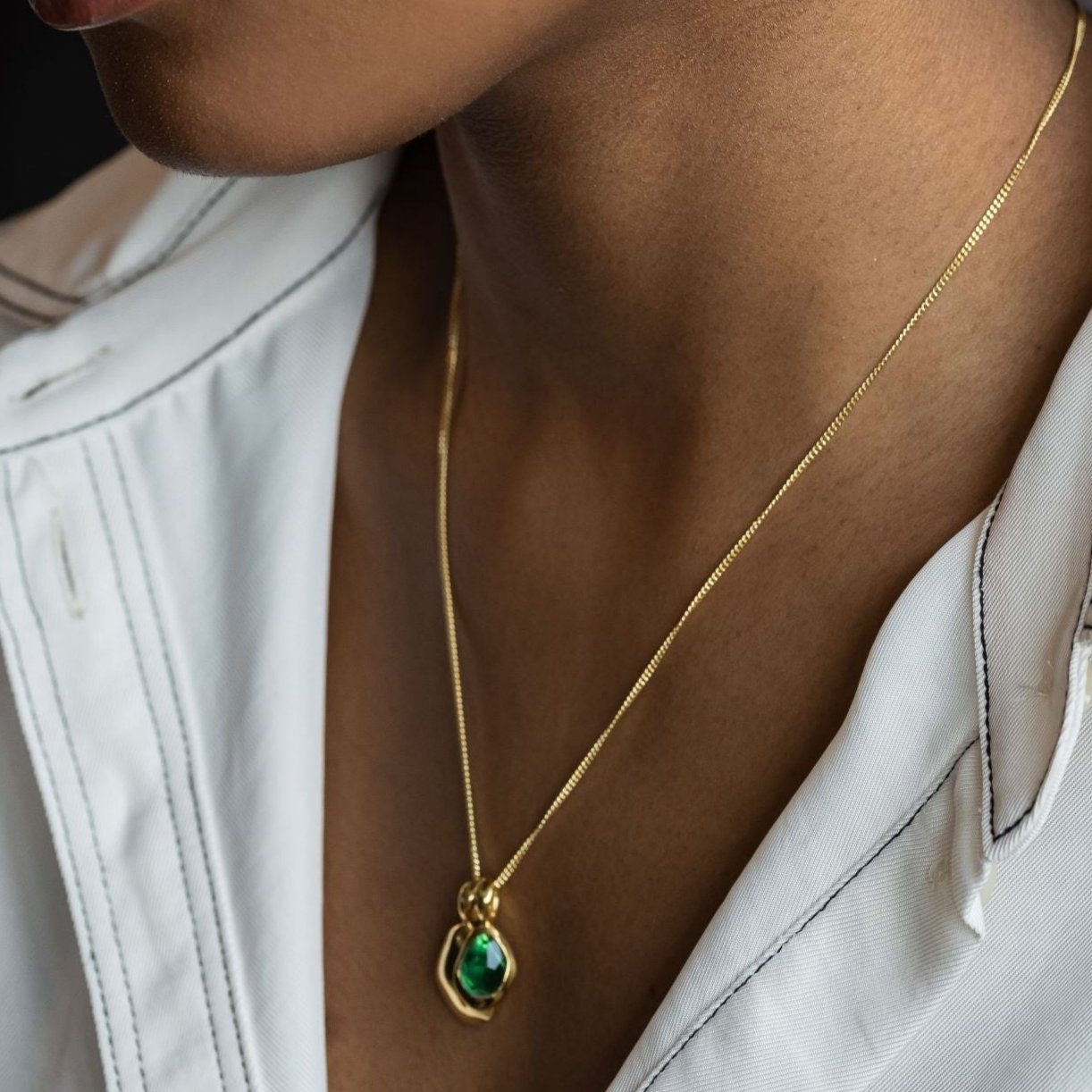 Pebble Charms necklace features a smooth, polished Pebble charm, nestled alongside a sparkling handcut Gemstone charm.