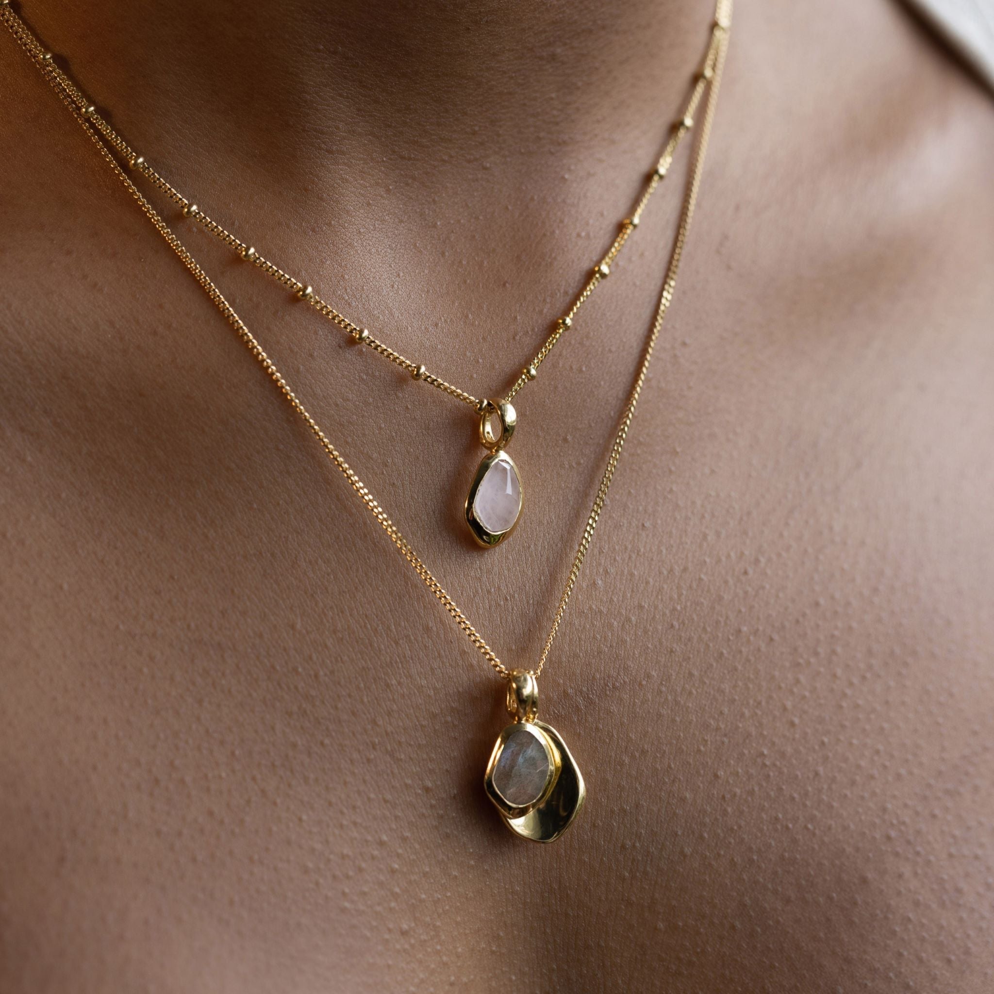 Pebble Charms necklace features a smooth, polished Pebble charm, nestled alongside a sparkling handcut Gemstone charm.